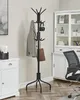 A coat rack with a jacket, headphones, and a bag hanging on it, placed in a room with furniture. Náhled obrázku produktu