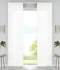 A view of a window with white panel curtains drawn to the sides, revealing a green landscape and sky outside. Produktbild-Vorschau