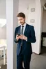A man in a suit is looking at his phone. Produktbild-Vorschau