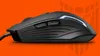 A black gaming mouse is shown in profile against an orange background with a faint logo. Anteprima dell’immagine prodotto