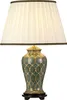 A table lamp with a pleated ivory shade and a decorative green ceramic base with gold accents. Podgląd zdjęcia produktu