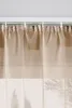 A close-up view of sheer curtains hanging from a curtain rod. Produktbild-Vorschau