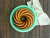 A bundt cake on a teal plate on a wooden surface. Podgląd zdjęcia produktu