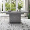 A dining table set in a bright room with large windows and greenery outside. Produktbild-Vorschau