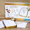 A Harry Potter themed luminous drawing board product box and its contents are displayed on a wooden surface. Produktbild-Vorschau