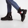 A person wearing blue jeans and black boots. Produktbild-Vorschau