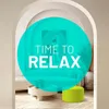 A bright green pouf sits in a modern living room setting, with a large teal circle overlay containing text. Anteprima dell’immagine prodotto