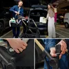 A family packing a stroller and car seat into a car trunk in a parking garage. Voir les images du produit