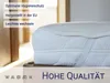 A close-up view of a mattress topper on a mattress, with text overlays highlighting product features and quality. Produktbild-Vorschau