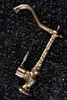 A bronze-colored faucet is placed on a dark, textured surface. Podgląd zdjęcia produktu