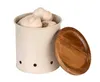 A cream-colored metal garlic keeper with a wooden lid and garlic bulbs inside, set against a white background. Produktbild-Vorschau