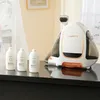 A white and orange Uwant fabric stain remover machine with three cleaning solution bottles on a dark surface. Podgląd zdjęcia produktu