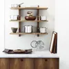 A kitchen shelf displaying various pots and pans, with a bread tray and loaf on the counter below. Anteprima dell’immagine prodotto