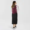 A woman wearing a backpack and a denim skirt, viewed from the back. Produktbild-Vorschau