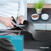 A person is cutting a black mat with scissors, with pet bowls and a plant in the background. Produktbild-Vorschau