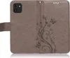 A brown flip case for a Samsung Galaxy A03 (2022) phone, featuring a floral and butterfly embossed design. Produktbild-Vorschau