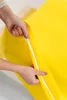 Hands zipping up a yellow duvet cover. Podgląd zdjęcia produktu