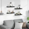 Four black wall shelves are mounted on a white wall above a grey sofa. The shelves are decorated with various vases, picture frames, and decorative items. Podgląd zdjęcia produktu