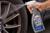 A person is spraying a wheel cleaner onto a car wheel. Produktbild-Vorschau
