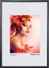 A woman with autumn leaves in her hair and on her shoulder, with a soft pink background. Produktbild-Vorschau