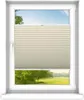A window with a beige-creme pleated blind partially covering the view of a green landscape with trees and a blue sky. Produktbild-Vorschau
