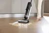 A person is using a wet and dry vacuum cleaner to clean up a spill on a wooden floor. Náhled obrázku produktu