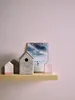 Decorative items on a shelf against a pink wall. Produktbild-Vorschau