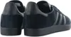 A close-up, rear-view shot of a pair of black Adidas Gazelle sneakers. Voir les images du produit