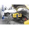 A car battery charger is connected to a car engine in a workshop setting. Anteprima dell’immagine prodotto