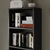 A close-up view of a black bookshelf filled with books and decorative boxes. Anteprima dell’immagine prodotto