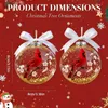 Two Christmas tree ornaments with red cardinals inside clear, glitter-filled spheres, set against a red background with festive decorations. Produktbild-Vorschau