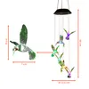 A product image showing a solar-powered wind chime with hummingbird decorations and a separate hummingbird for scale, with dimensions indicated. Voir les images du produit