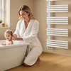 A mother is bathing her child in a bathtub, with a white towel warmer mounted on the wall in the background. Náhled obrázku produktu
