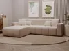 A modern beige sectional sofa is arranged in a living room setting with artwork on the wall and a rug on the floor. Produktbild-Vorschau