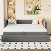 A gray daybed with a white mattress and decorative pillows is shown in a room with a bookshelf and a painting on the wall. Produktbild-Vorschau