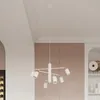 A white chandelier hangs from the ceiling in a room with pink and white walls. Podgląd zdjęcia produktu