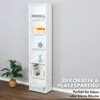 A tall, narrow white bookshelf is shown against a light gray wall, with a plant in a basket to the left. Text overlays highlight its decorative and space-saving features. Produktbild-Vorschau