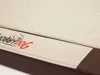 A close-up view of a dog bed, showing the quilted top and a side band with a logo. Produktbild-Vorschau