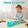 Lächelndes Baby spielt mit einem leuchtenden türkisfarbenen Raupenspielzeug, das durchsichtige Abschnitte mit bunten Zahnrädern und den Buchstaben A, B, Y hat Anteprima dell’immagine prodotto