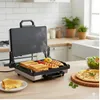 A kitchen counter with a grill, food, and salad. Produktbild-Vorschau
