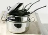 A stack of stainless steel pots and pans with a lid, placed on a wooden surface. Voir les images du produit