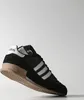 A black Adidas sneaker with white stripes and tan sole, shown from the side against a white background. Náhled obrázku produktu
