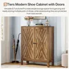 A modern shoe cabinet with doors is shown in an entryway setting, with umbrellas in a stand next to it. Náhľad obrázku produktu