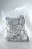 A large clear plastic bag filled with many small individually wrapped packets. Produktbild-Vorschau