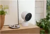 A Google Nest Cam is placed on a wooden shelf next to a small dish of keys and a potted plant. Voir les images du produit