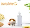 A white electric hand mixer is shown next to a cup of coffee with latte art, a macaron, and a slice of cake. Text overlays describe the product's features. Náhľad obrázku produktu