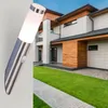 A modern house with a well-maintained lawn and a walkway, with a wall-mounted light fixture in the foreground. Produktbild-Vorschau
