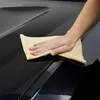 A hand is shown polishing the hood of a black car with a yellow microfiber cloth. Produktbild-Vorschau