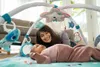 A mother and her baby are playing on a baby gym mat. Produktbild-Vorschau