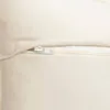 A close-up view of a zipper on a cream-colored cushion. Náhled obrázku produktu